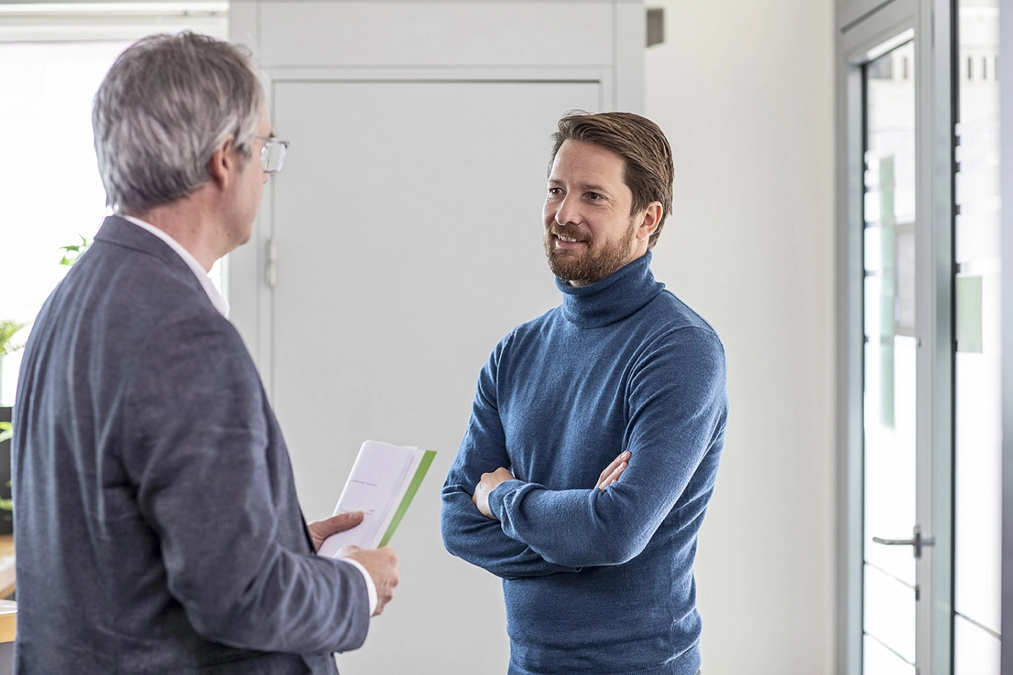 Klant en bankadviseur van Alitos bespreken verzekering details tijdens een gesprek.